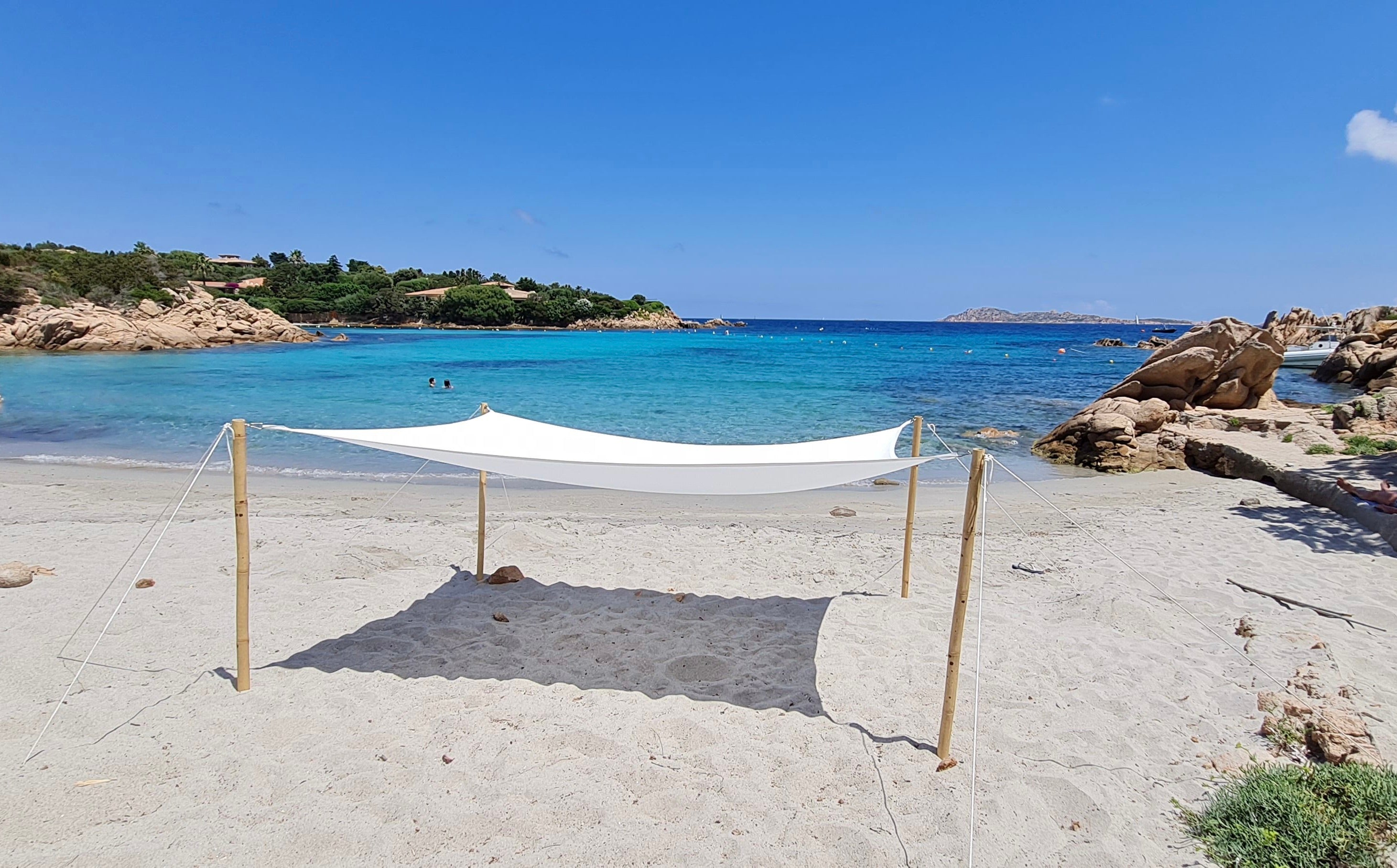 Beach with a white canopy set up on a clear day